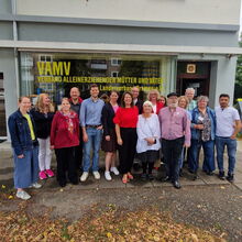 Gruppenfoto mit vielen Menschen vor dem Gebäude mit Schriftzug VAMV Verband alleinerziehender Mütter und Väter