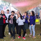 Gruppe von fröhlichen Menschen vor einem Festivalzelt