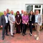 Personengruppe vor einem Haus mit Hortensien