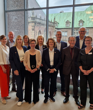 Gruppen von Männern und Frauen in Anzügen aufgestellt für ein Gruppenfoto