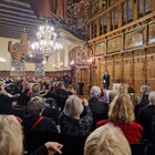 Viele Menschen sitzen in der Oberen Rathaushalle in Bremen, vorne steht ein Mann.
