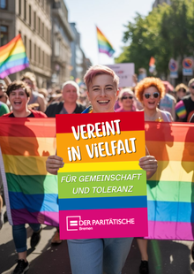 Frontalaufnahme eines Demozugs mit Regenbogenflaggen. Die Person im Vordergrund lächelt und hält ein Plakat in der Hand: Vereint in Vielfalt - Der Paritätische Bremen
