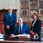 Festlicher Schreibtisch im Bremer Rathaus, ein Mann sitzt, zwei Personen stehen links und rechts daneben