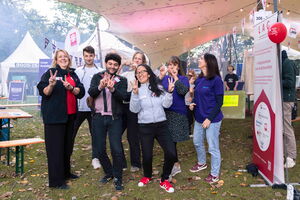 Gruppe von fröhlichen Menschen vor einem Festivalzelt