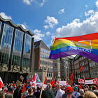 bunte Flagge mit Parität-Logo auf dem Bremer Marktplatz , im Hintergrund viele DGB-Flaggen und Menschen
